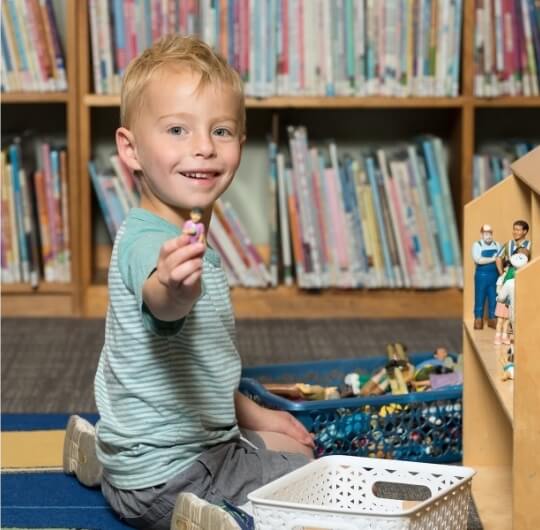 Boy Playing With Toy Figures At Red Land Library