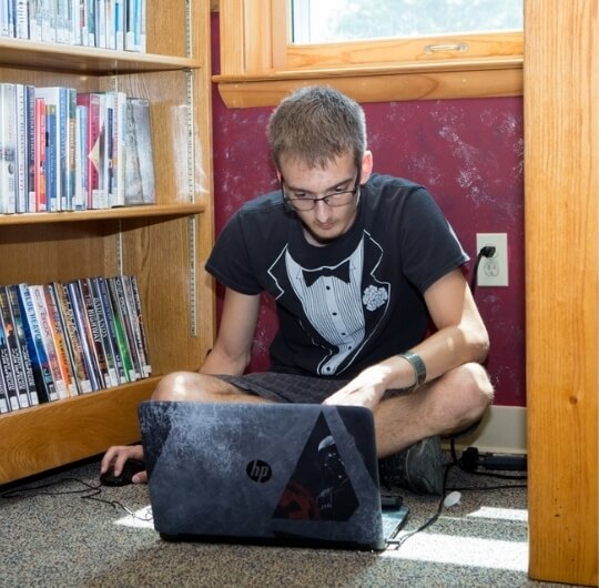 Teen Boy Using Laptop Inside Collinsville Library