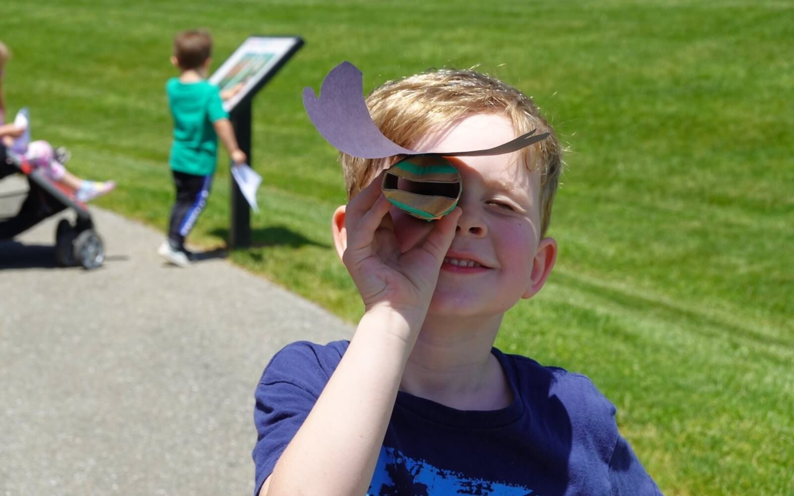 Little Boy Holding Craft At Storywalk Event