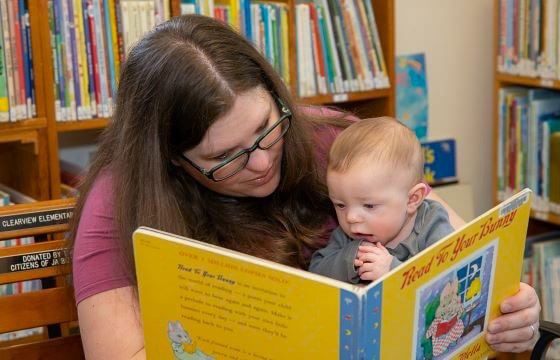 Mother Reads To Her Infant In The Library