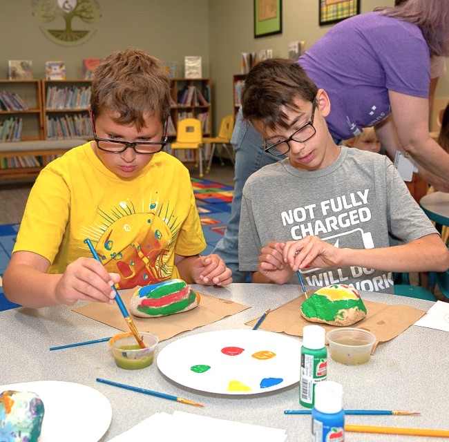 two boys painting rocks at craft event